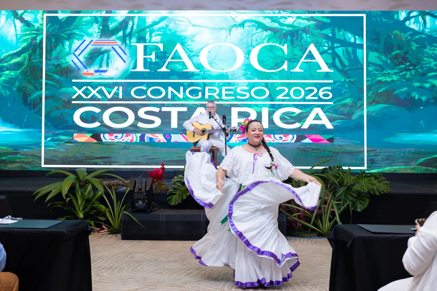 Baile folclórico costarricense en la inauguración de FAOCA Costa Rica 2026, frente a la pantalla LED con la marca del congreso
