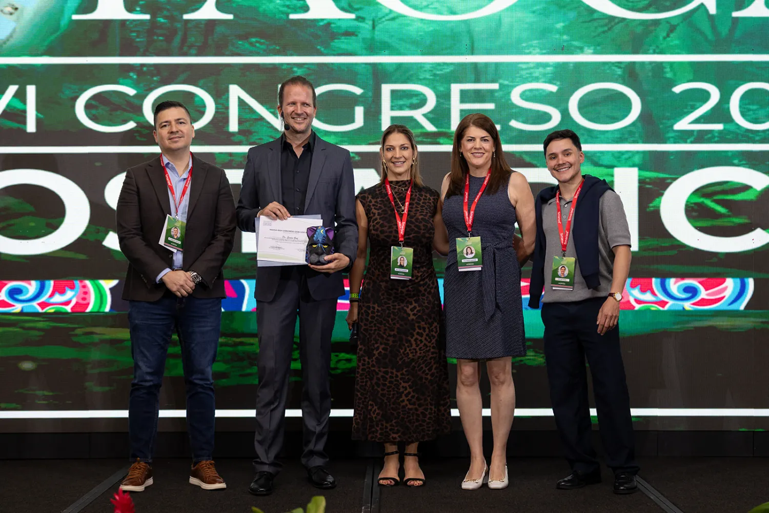 Entrega de reconocimientos en el escenario de FAOCA Costa Rica 2026, frente a la pantalla LED del congreso